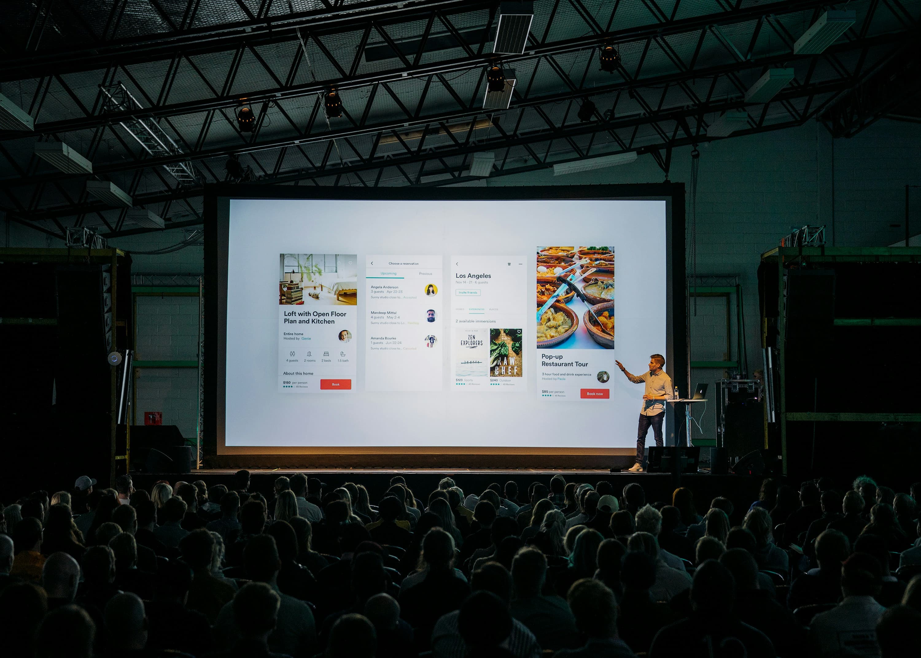 An auditorium audience facing a large presentation screen