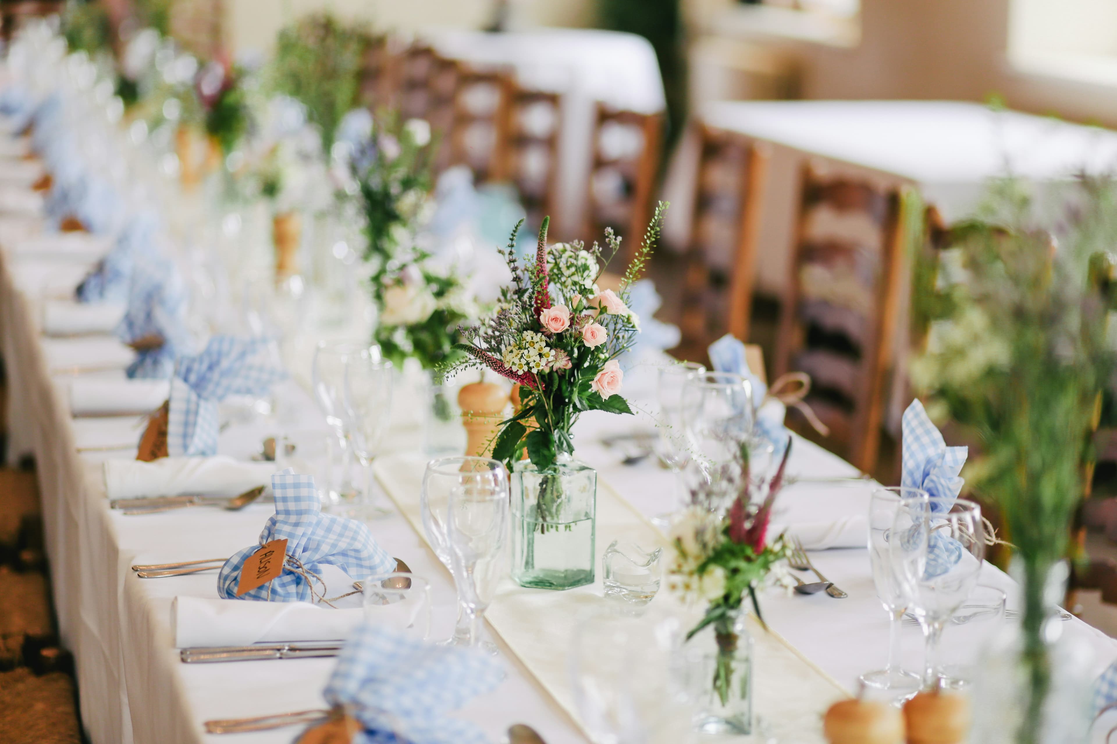 A long banquet table dressed with flowers and glassware