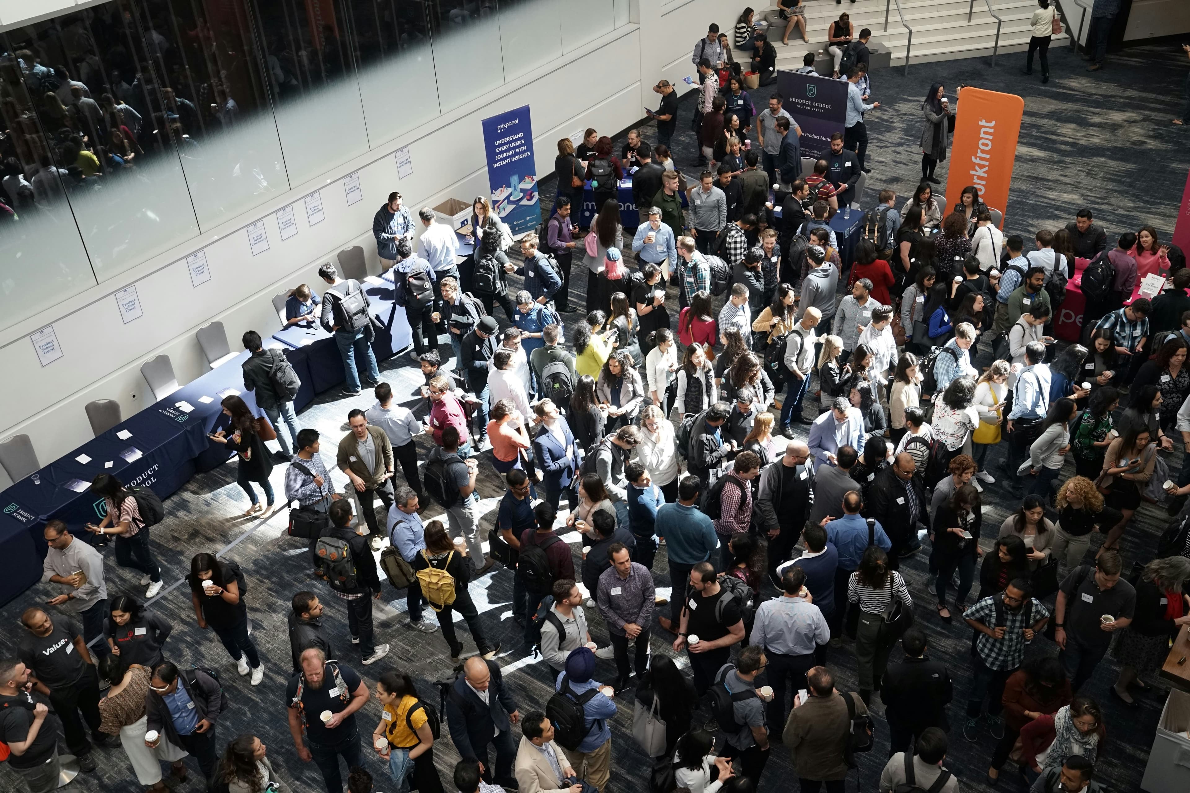 Visitors walking a busy exhibition floor between stalls